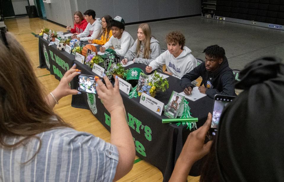 St. Mary's High School athletes Parker Orlando, left, Jacob Delaney, Alyssa Polk, Caden Ward, Sofia Pittis, Brayden Wilson and Legend Moore pave their picture take as they sign letters of intent to play for various colleges during a ceremony at the school in Stockton on Apr. 17, 2024.