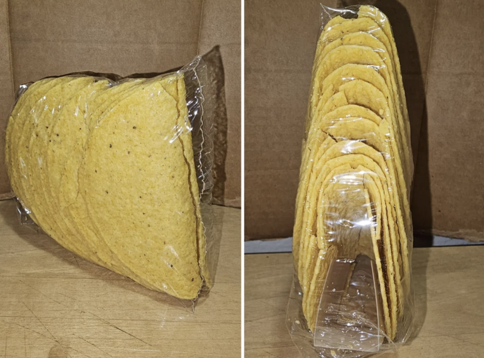 Taco shells in plastic packaging leaning sideways, some shells broken