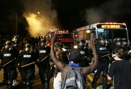 Police officers wearing riot gear block a road during protests after police fatally shot Keith Lamont Scott in the parking lot of an apartment complex in Charlotte, North Carolina. REUTERS/Adam Rhew/Charlotte Magazine