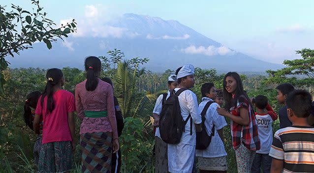 PICTURED: Residents observe the Mount Agung from a viewing point in Bali, Indonesia. Officials have raised its alert level for the second time in less than a week. Source: AAP
