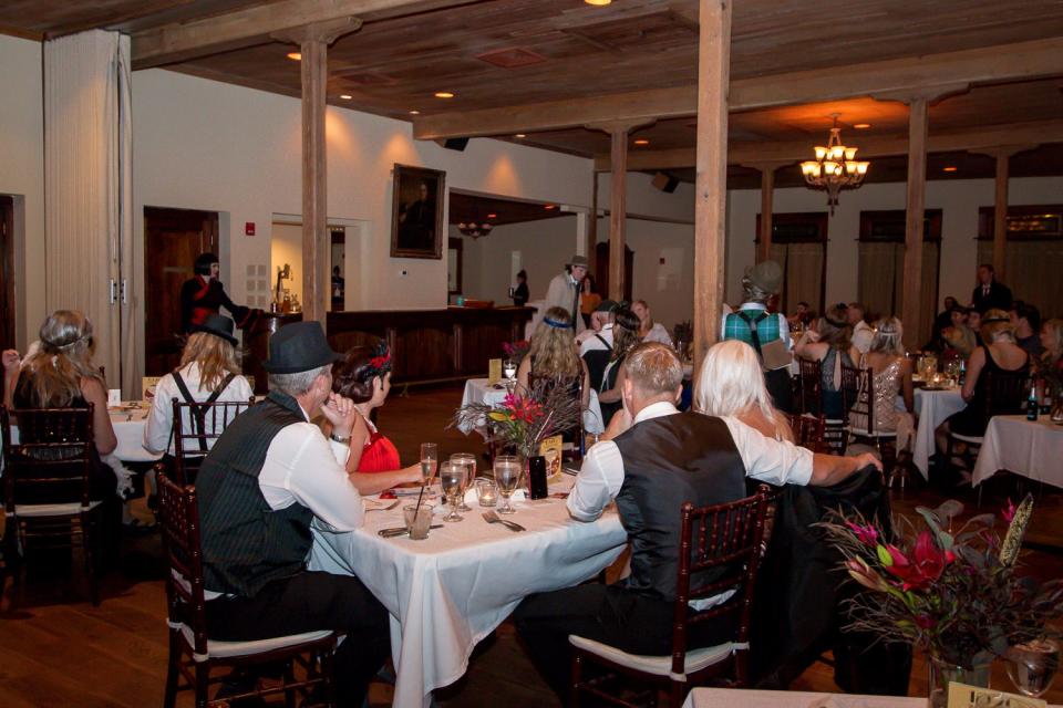 Guests listen for clues as they try to determine who the murderer was during a past Murder Mystery Dinner Show.