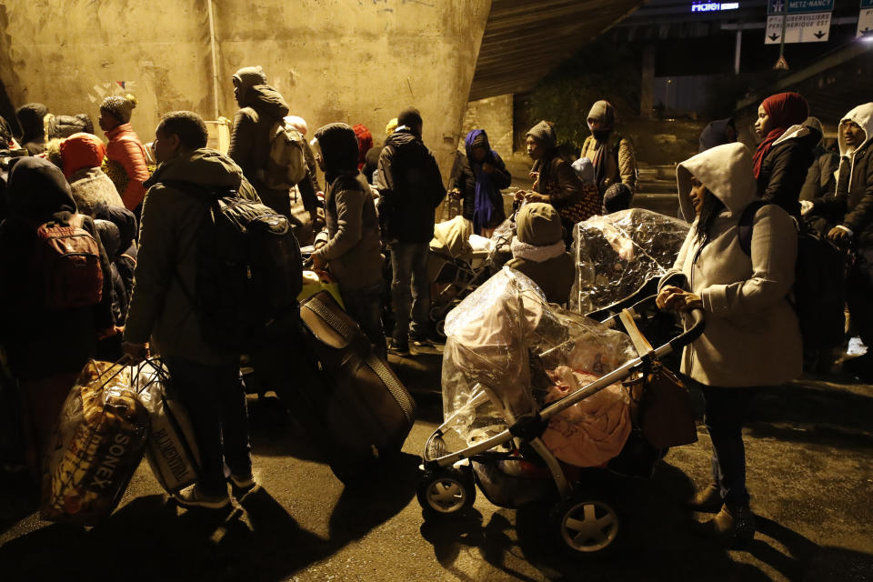 Migrants walk away as police forces clear an area Thursday, Nov. 7, 2019 in the north of Paris. Migrant encampments are becoming increasingly visible in the French capital. Police cleares Thursday several thousand people from a northern Paris neighborhood where migrants have repeatedly been removed. They are taken to shelters, and some eventually sent home. (AP Photo/Francois Mori)