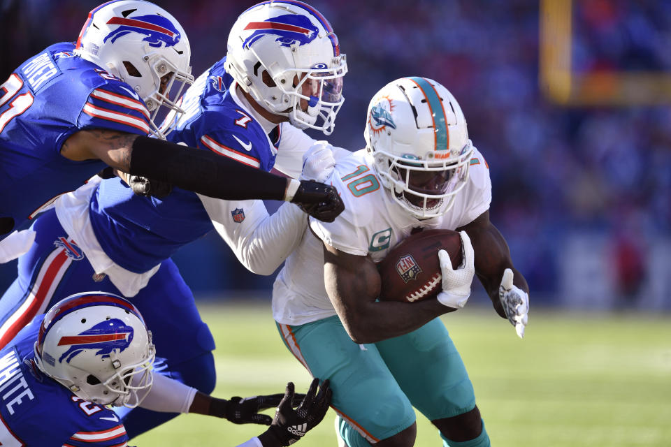 Miami Dolphins wide receiver Tyreek Hill (10), right, tries to break free from the Buffalo Bills defenders during the first half of an NFL wild-card playoff football game, Sunday, Jan. 15, 2023, in Orchard Park, N.Y. (AP Photo/Adrian Kraus)