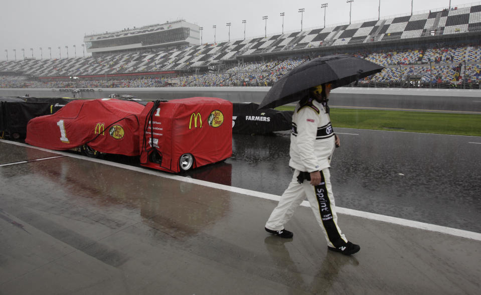 A NASCAR official walks down pit road during a rain delay in the start of the NASCAR Daytona 500 Sprint Cup series auto race in Daytona Beach, Fla., Sunday, Feb. 26, 2012. (AP Photo/Terry Renna)