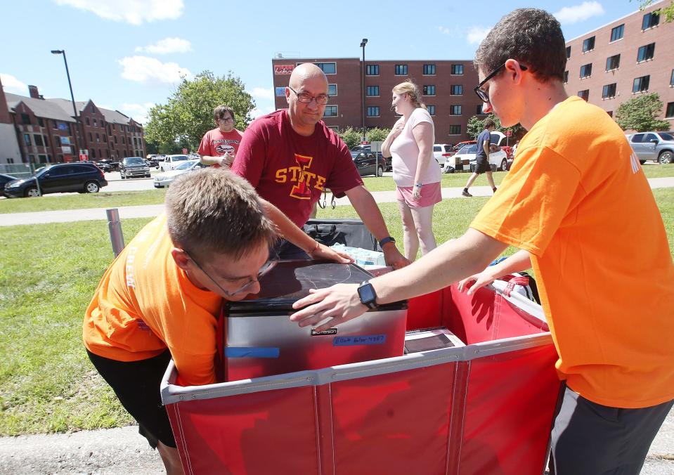 Iowa State University student volunteers Sam Pershing and Ryan Price help new students move into the Friley Residence Hall on Tuesday, Aug. 15, 2023, in Ames, Iowa.