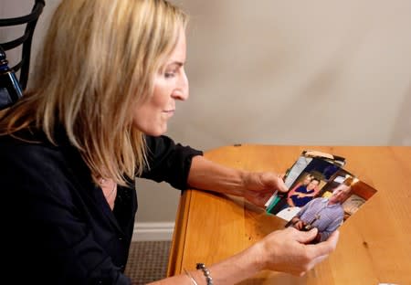 Kelly Pfaff goes through pictures of her husband John as she talks about her husband's death during an interview at her home in Park City