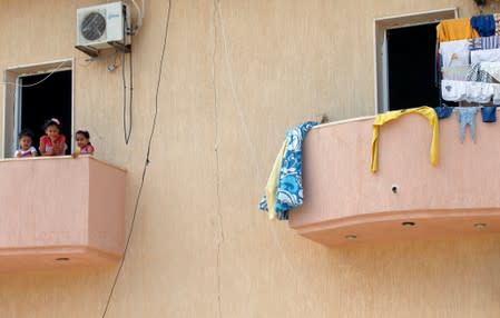 Displaced Libyan children who fled after clashes, are seen at balcony of a hotel used as a shelter in Tajura neighborhood, east of Tripoli