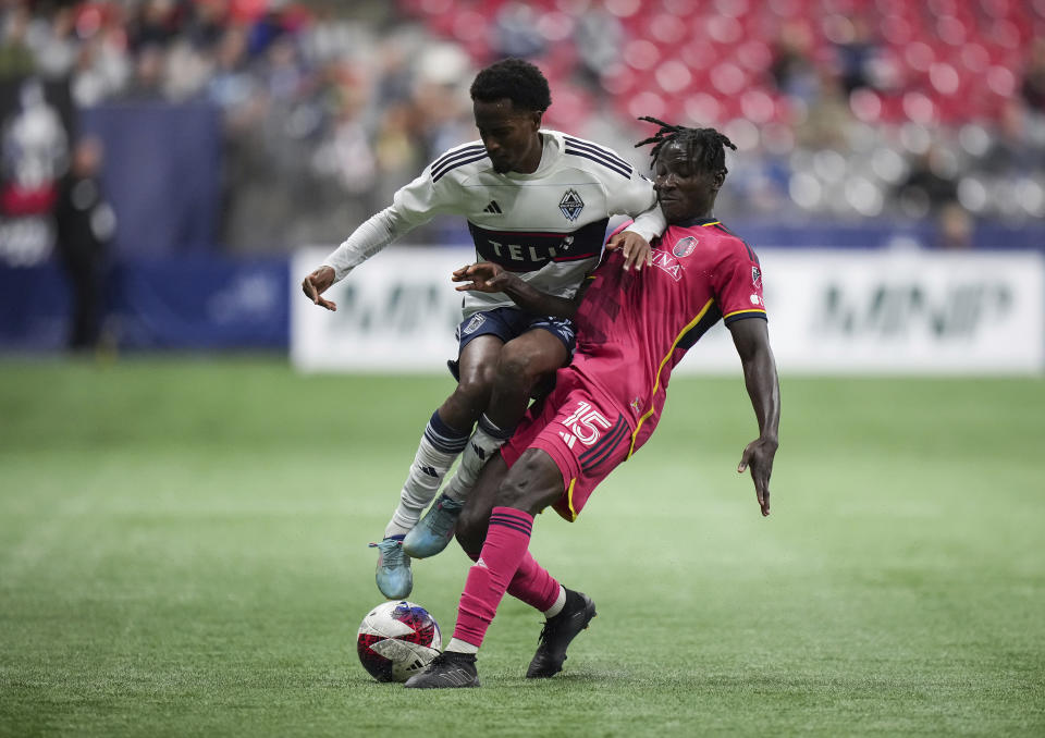 Vancouver Whitecaps' Ali Ahmed, left, and St. Louis City's Joshua Yaro collide as they vie for the ball during the first half of an MLS soccer match Wednesday, Oct. 4, 2023, in Vancouver, British Columbia. (Darryl Dyck/The Canadian Press via AP)