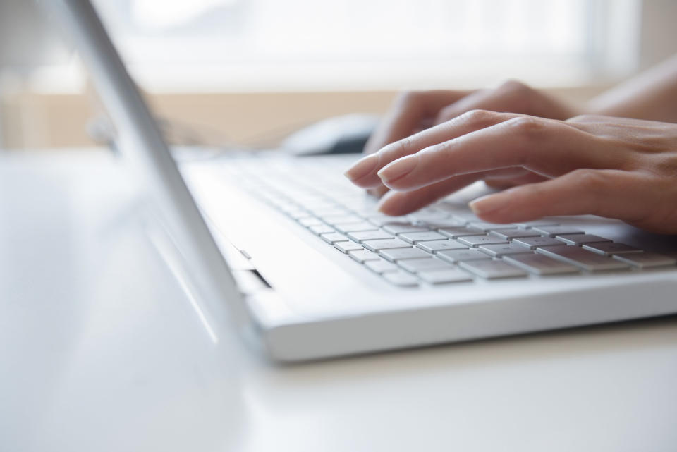 close up of fingers typing on a computer