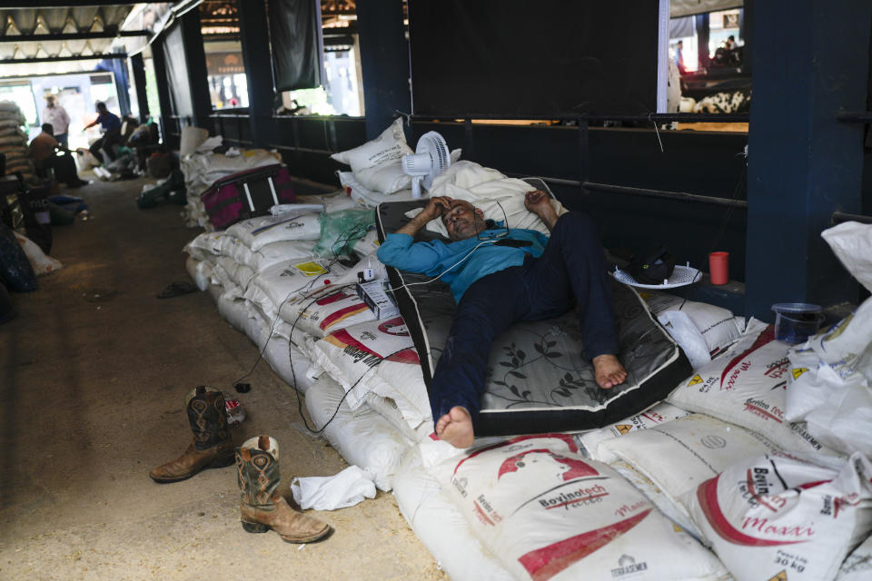 A stockman rests inside a stable during the ExpoZebu fair in Uberaba, Minas Gerais state, Saturday, April 27, 2024. Uberaba holds an annual gathering called ExpoZebu that bills itself as the world’s biggest Zebu fair. (AP Photo/Silvia Izquierdo)