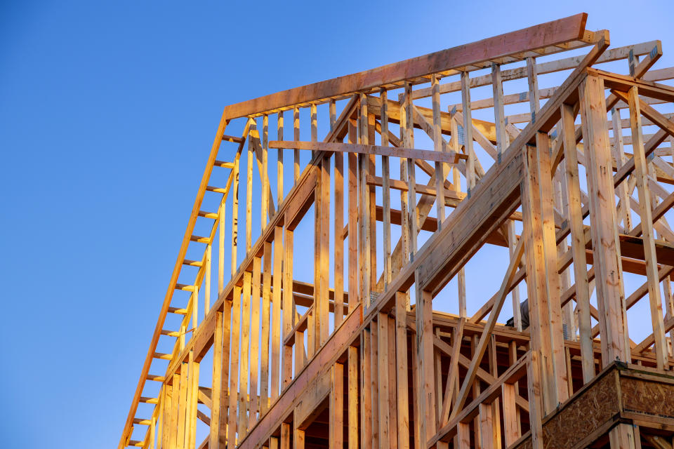 New residential construction home framing home against a blue sky