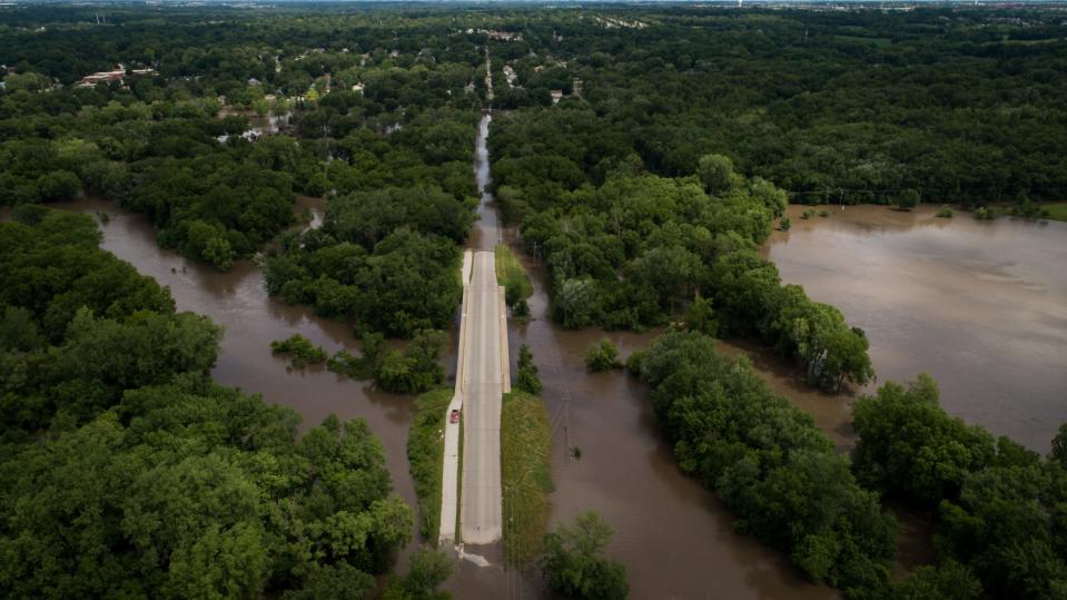 Flood waters spill over Four Mile Creek on Sunday, July 1, 2018 after flash flooding Saturday night in Des Moines.