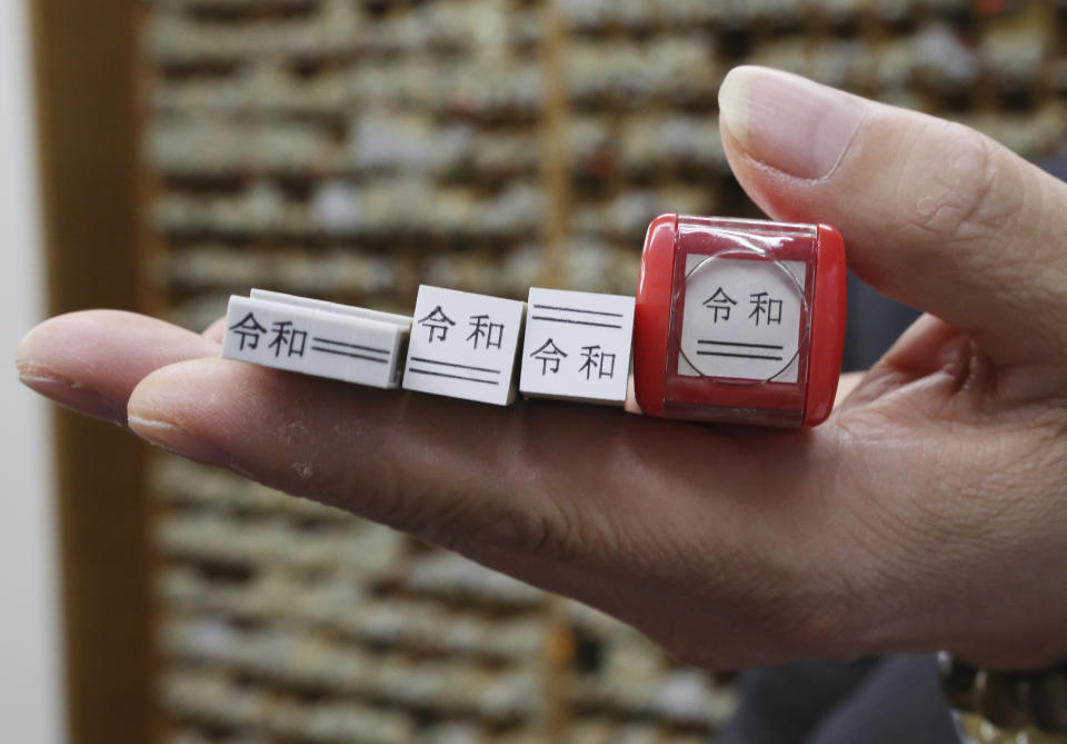 In this April 10, 2019, photo, samples of Reiwa era labeling stamps are shown by Shigeo Kojima, managing director of Kippodo stamp company, during an interview in Tokyo. Japan is getting ready for its biggest celebration in years with the advent of the Reiwa era of soon-to-be emperor Naruhito. That means big opportunities for businesses hoping consumers will splash out on long holidays and memorabilia. (AP Photo/Koji Sasahara)