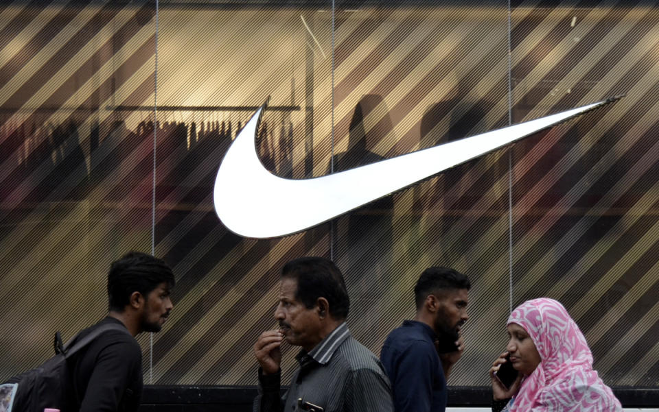 People walk past a signage of Nike logo in a famous shopping hub in Bangalore, India, 25 July, 2023.
