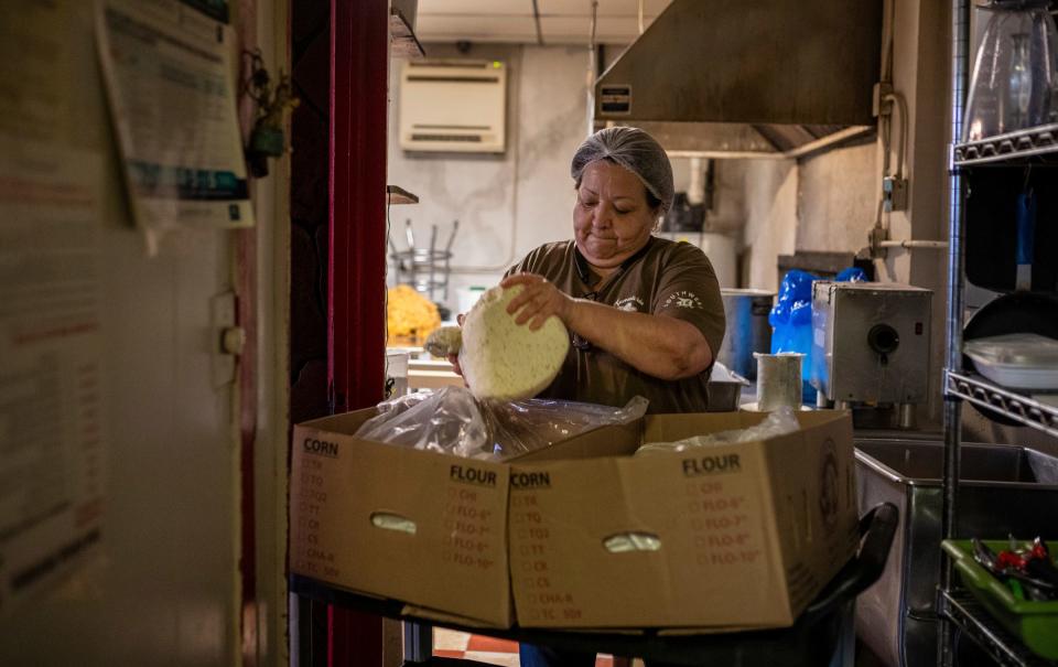 La dueña de Tamalería Nuevo León, Susana "Suzy" Villarreal-Garza, recoge un gran trozo de masa hecha de maíz dentro de Tamalería Nuevo León, en el suroeste de Detroit, el viernes 3 de marzo de 2023.