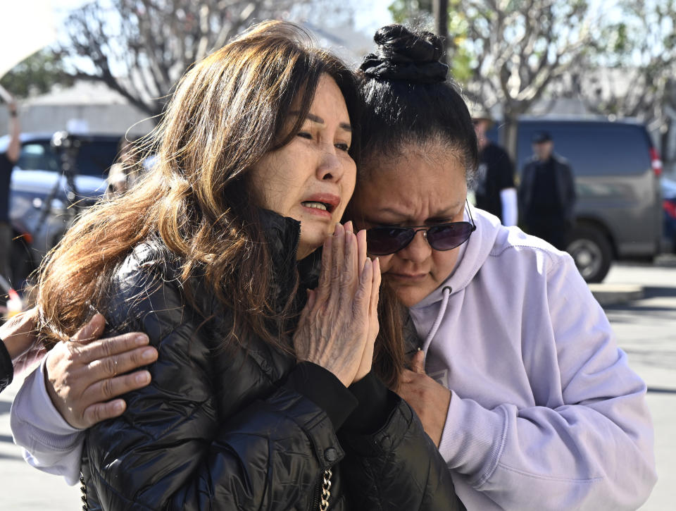 A woman, left, who knew Yu Kao, one of the victims, is consoled in front of a makeshift memorial in front of the Star Ballroom Dance Studio in Monterey Park, Calif., Tuesday, Jan. 24, 2023. A gunman killed multiple people at the Star Ballroom Dance Studio late Saturday, Jan. 21, amid Lunar New Years celebrations in the predominantly Asian American community of Monterey Park. (Keith Birmingham/The Orange County Register via AP)