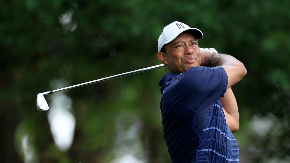 golfer tiger woods watching his shot and holding his club after his follow through