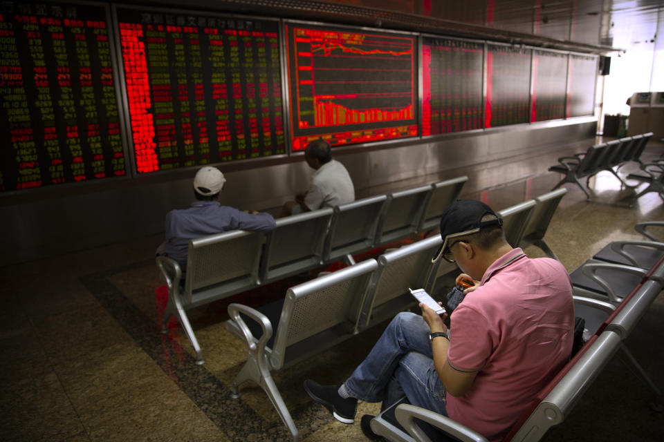 A Chinese investor uses his smartphone as he monitors stock prices at a brokerage house in Beijing, Wednesday, Sept. 11, 2019. Asian shares were mostly higher Wednesday, cheered by a rise on Wall Street amid some signs of easing tensions between the U.S. and China on trade issues. (AP Photo/Mark Schiefelbein)