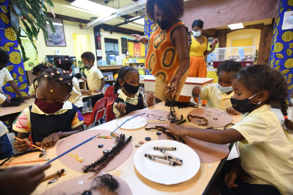 Aaliyah Barclift works with children as they create self-portraits at the Little Sun People preschool in Brooklyn, N.Y.