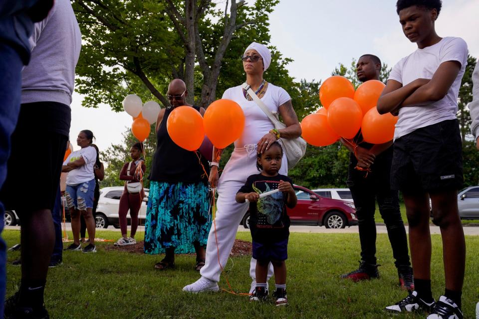 Stephanie Mosley, of Detroit, and Jaxon Hare, 3, listen to speakers during a vigil honoring Khalil Amari Allen, 18, in Southfield on Friday, July 14, 2023. Hare is Allen's nephew. Allen was shot and killed while driving to get food the evening of July 11.