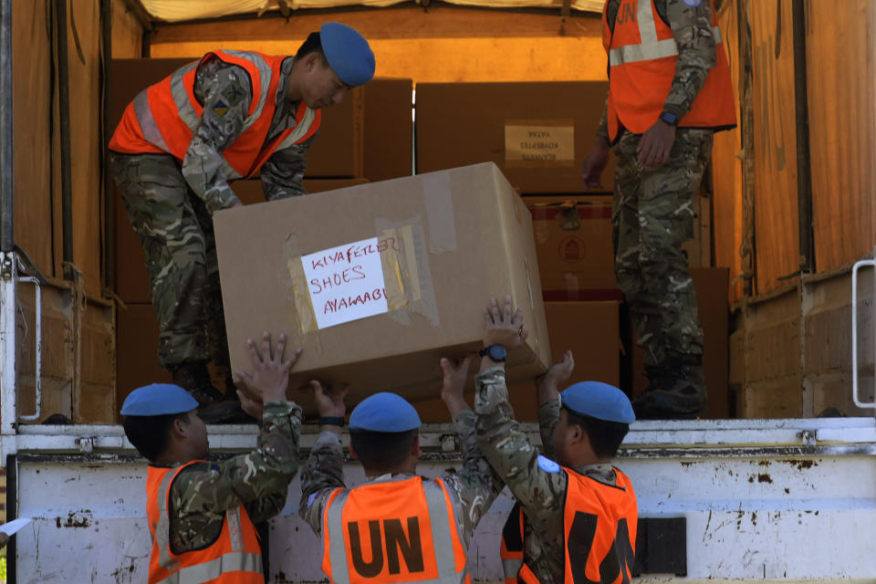 British soldiers serving with the United Nations Peacekeeping Force in Cyprus (UNFICYP) load a truck with 105 boxes of food, clothing, water and blankets donated by Greek Cypriots in the south of the ethnically divided island nation to be transferred to the breakaway Turkish Cypriot north from where it will be taken to Turkey for distribution to earthquake victims at the vacant Ledra Palace hotel inside a U.N. controlled buffer zone in the divided capital Nicosia, Cyprus, Wednesday, Feb. 15, 2023. The earthquake in Turkey has prompted ordinary citizens on both sides of the divided island to cast aside politics and start collecting money and other aid for the quake victims. (AP Photo/Petros Karadjias)