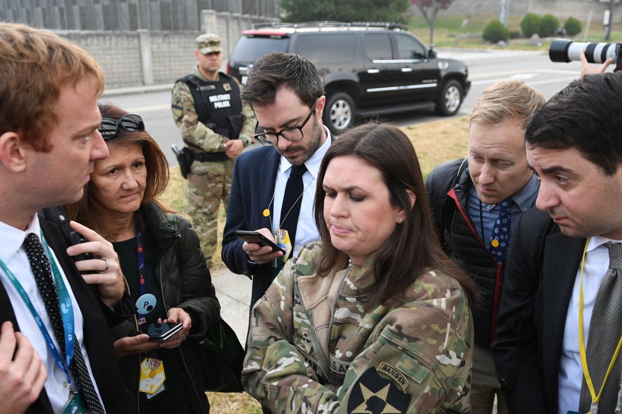 White House press secretary Sarah Huckabee Sanders (center) speaks to reporters after&nbsp;the helicopters returned from the aborted DMZ visit. (Photo: JIM WATSON/AFP/Getty Images)