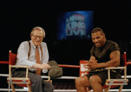 FILE - In this Aug. 16, 1995 file photo, former heavyweight champion Mike Tyson, right, shares a laugh with TV talk show host Larry King during the broadcasting of the "Larry King Live" show from inside the ring at the MGM Grand Gardens in Las Vegas. King, who interviewed presidents, movie stars and ordinary Joes during a half-century in broadcasting, has died at age 87. Ora Media, the studio and network he co-founded, tweeted that King died Saturday, Jan. 23, 2021 morning at Cedars-Sinai Medical Center in Los Angeles. (AP Photo/Lennox McLendon, File)