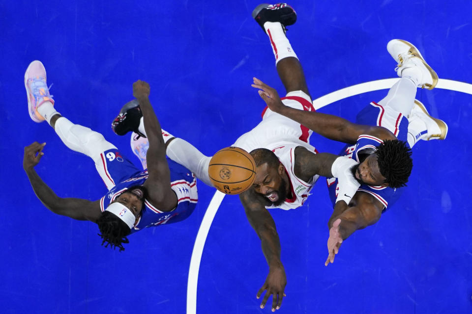 Houston Rockets' Jeff Green, center, tries to get a shot past Philadelphia 76ers' Joel Embiid, right, and Patrick Beverley during the first half of an NBA basketball game, Monday, Jan. 15, 2024, in Philadelphia. (AP Photo/Matt Slocum)