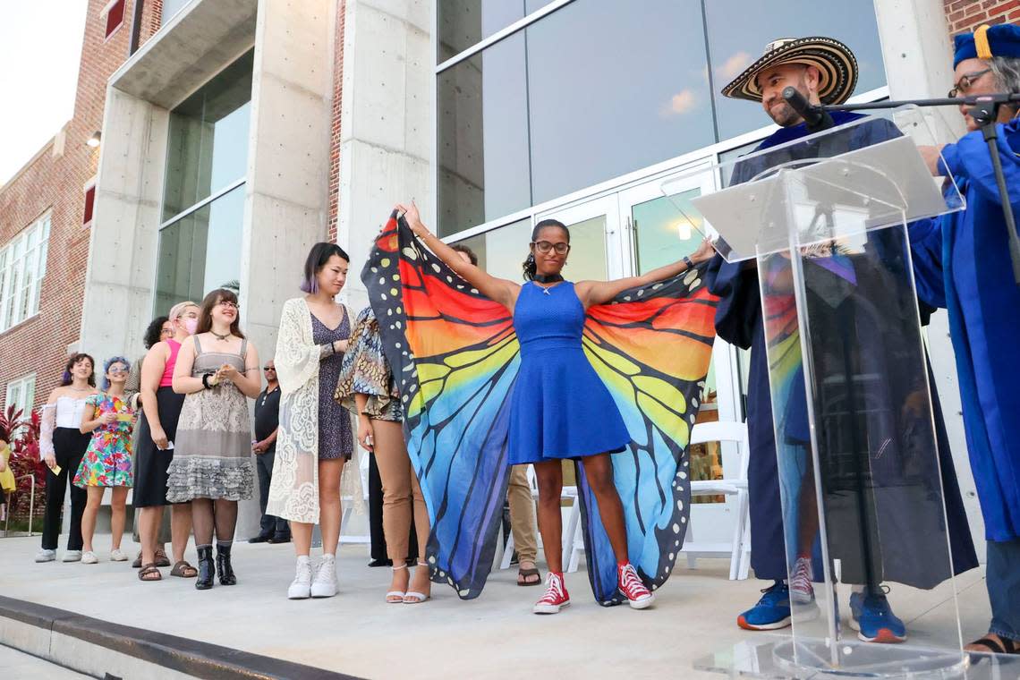 New College of Florida graduating student Grace Sherman spreads her wings while being announced during a procession of students during the college’s “alternative commencement” on Thursday, May 18, 2023, in Sarasota. Douglas R. Clifford/Tampa Bay Times