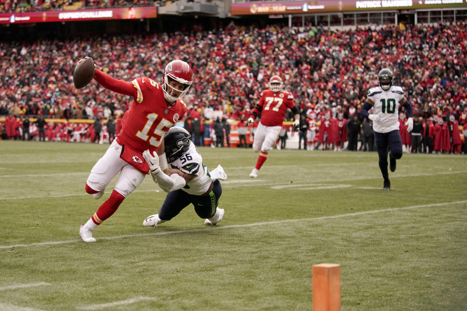 Kansas City Chiefs quarterback Patrick Mahomes (15) head for the end zone past Seattle Seahawks linebacker Jordyn Brooks (56) to score during the second half of an NFL football game Saturday, Dec. 24, 2022, in Kansas City, Mo. (AP Photo/Charlie Riedel)