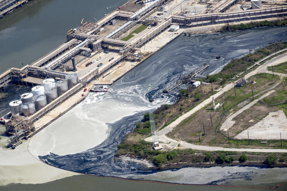 In a Wednesday, March 20, 2019 photo, runoff from the now-extinguished petrochemical tank fire at Intercontinental Terminals Company is blocked by an oil skimming buoy, in Deer Park, Texas. Fire crews extinguished the blaze at ITC about 3 a.m., Wednesday, almost four days after it started, which caused a plume of black smoke to linger over the Houston area. ITC officials said the cause of the fire is still unknown. (Brett Coomer/Houston Chronicle via AP)