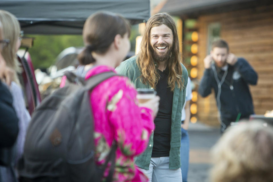 Dan Price, CEO de Gravity Payments, al centro con cabello largo, conversa con empleados en 2015 tras anunciar el aumento salarial (Katherine Jones/Idaho Statesman/Tribune News Service via Getty Images)