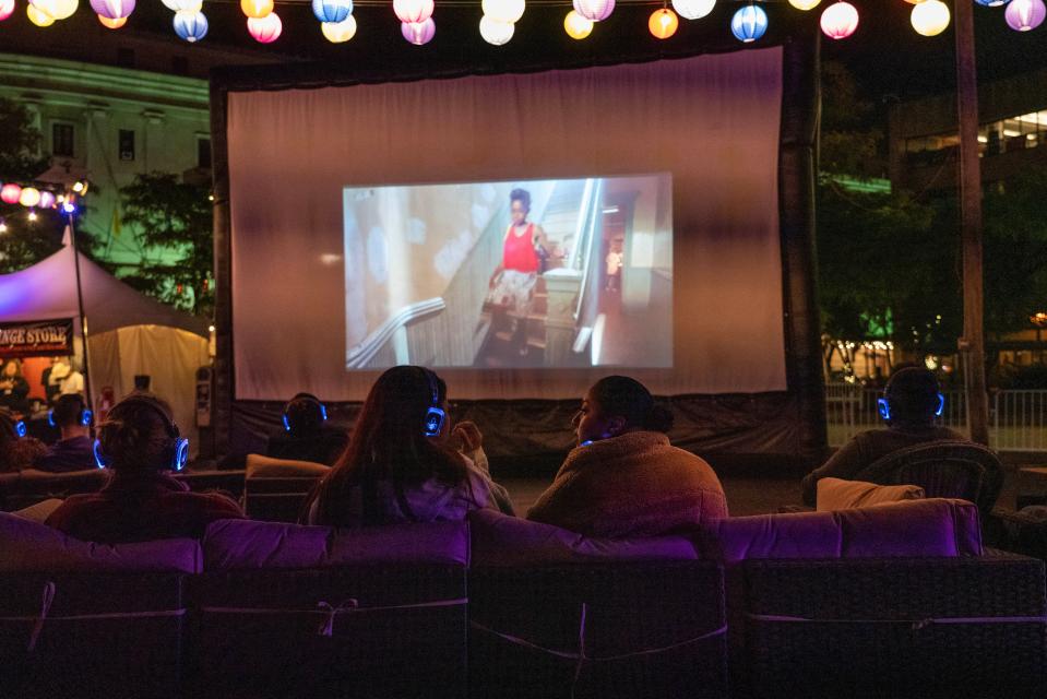 Guests enjoy watching a film shown outside the Spiegeltent at the 2023 Rochester Fringe Festival.