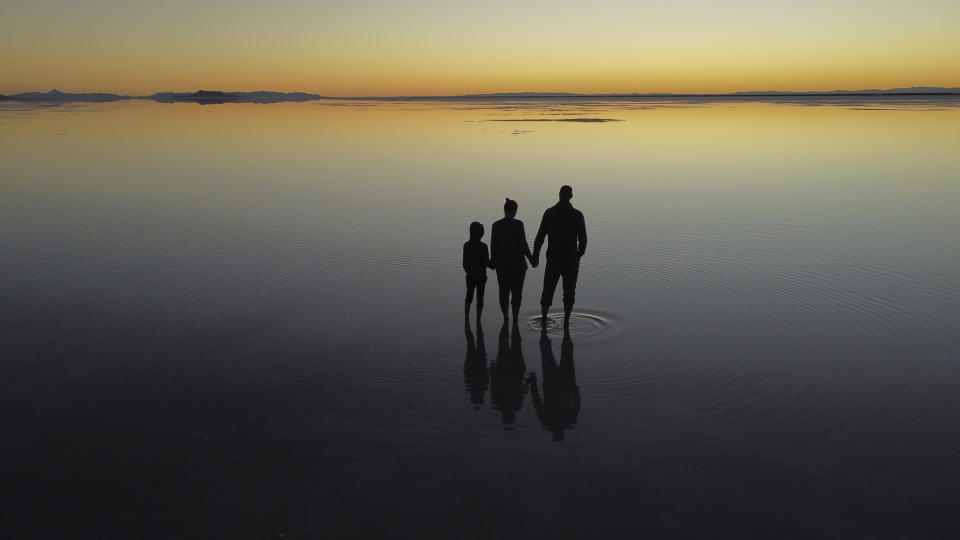 Visitors watch sunrise at the Bonneville Salt Flats on Monday, Sept. 19, 2022, near Wendover, Utah. (AP Photo/Rick Bowmer)