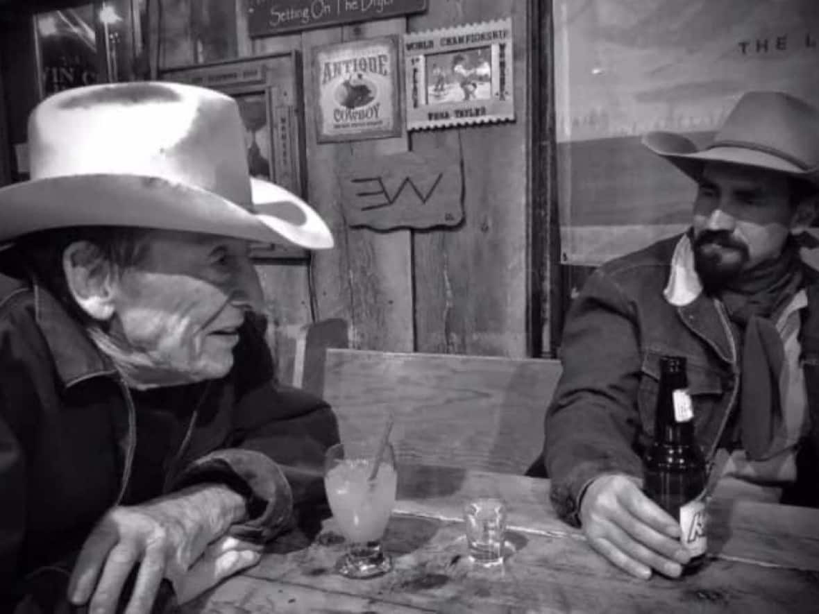 Tyson, left, sits at a table at the Twin Cities Saloon in Longview, Alta. (Chris Goss - image credit)