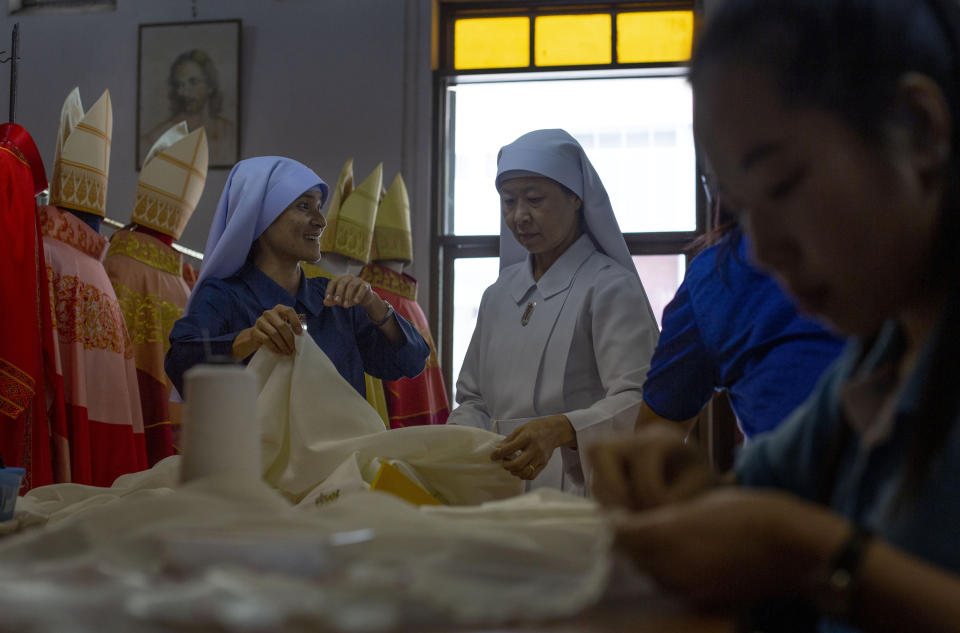 In this Friday, Nov. 8, 2019, photo, seamstresses from the Congregation of the Sacred Heart of Jesus Sisters of Bangkok snip and sew at a Catholic preparatory school in Bangkok, Thailand. A 11-member team of Sisters have been racing the clock, 10 hours a day, stitching almost 200 ceremonial garments for Pope Francis and accompanying bishops for Pope Francis four-day visit to Thailand later this month. (AP Photo/Gemunu Amarasinghe)