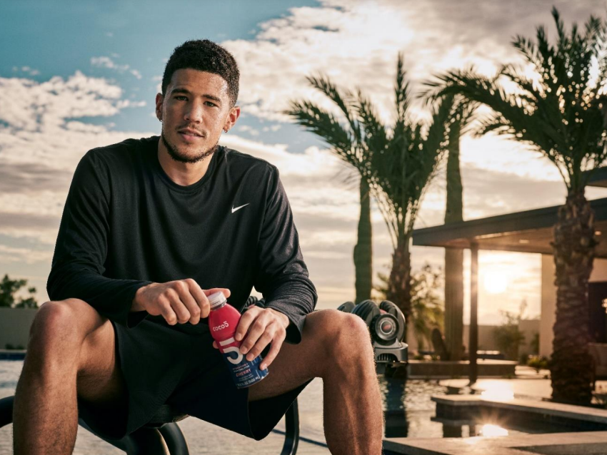 Devin Booker holds a bottle of Coco5 for a promotional ad of the all-natural beverage.