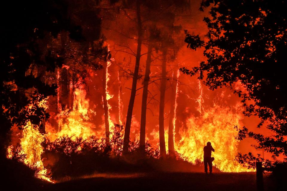 -- AFP ENVIRONMENT PICTURES OF THE YEAR 2022 -- 

A silhouette is seen in front of flames at a wildfire near Belin-Beliet, southwestern France, overnight on August 11, 2022. - French officials warned that flare-ups could cause a massive wildfire to further spread in the country's parched southwest, where fresh blazes have already blackened swathes of land this week. Prime Minister is expected to meet with authorities battling the Landiras blaze south of Bordeaux, and further reinforcements are expected for the 1,100 firefighters on site, the prefecture of the Gironde department said. (Photo by Thibaud MORITZ / AFP) / AFP ENVIRONMENT PICTURES OF THE YEAR 2022