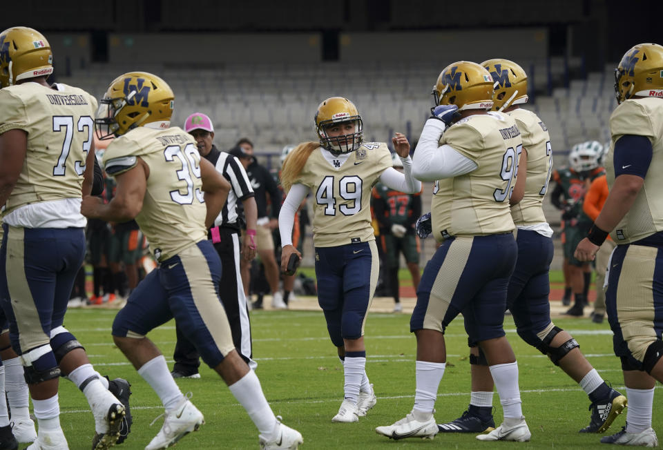 Pumas' Andrea Martinez walks with her teammates after failing a kick during a Liga Mayor football match against Aztecas in Mexico City, Saturday, Oct. 8, 2022. Martinez stopped playing soccer to become the first woman to play college football amongst men in Mexico's top amateur division. (AP Photo/Fernando Llano)