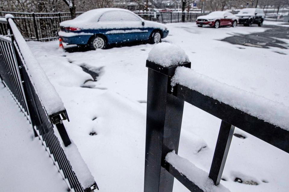 Snow-covered cars are parked on Market Street in Wilmington, Friday, January 19, 2024.