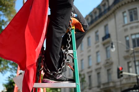 A climate change activist chains themself to a ladder while blocking traffic in downtown Washington