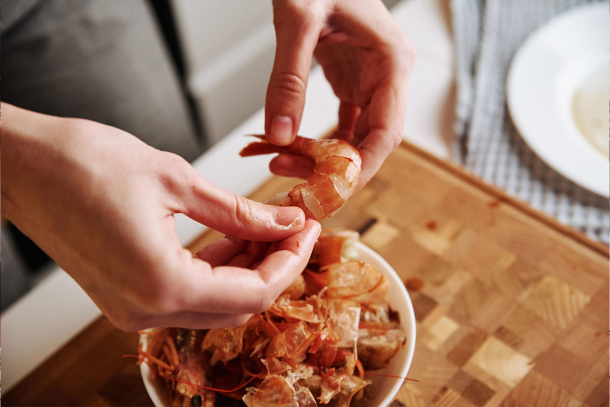 Woman cleaning shrimps for cooking Getty Images/Lazy_Bear