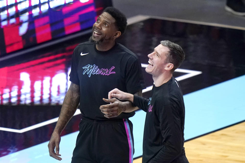 Miami Heat forward Udonis Haslem, left, talks with guard Goran Dragic before the team's NBA basketball game against the Philadelphia 76ers, Thursday, May 13, 2021, in Miami. (AP Photo/Lynne Sladky)