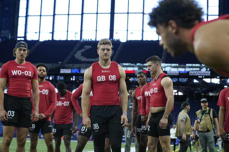 Kentucky quarterback Will Levis watches as other prospects stretch for measurements at the NFL football scouting combine in Indianapolis, Saturday, March 4, 2023. (AP Photo/Michael Conroy)