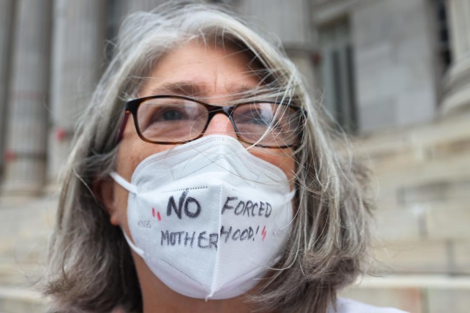 woman in mask with sign