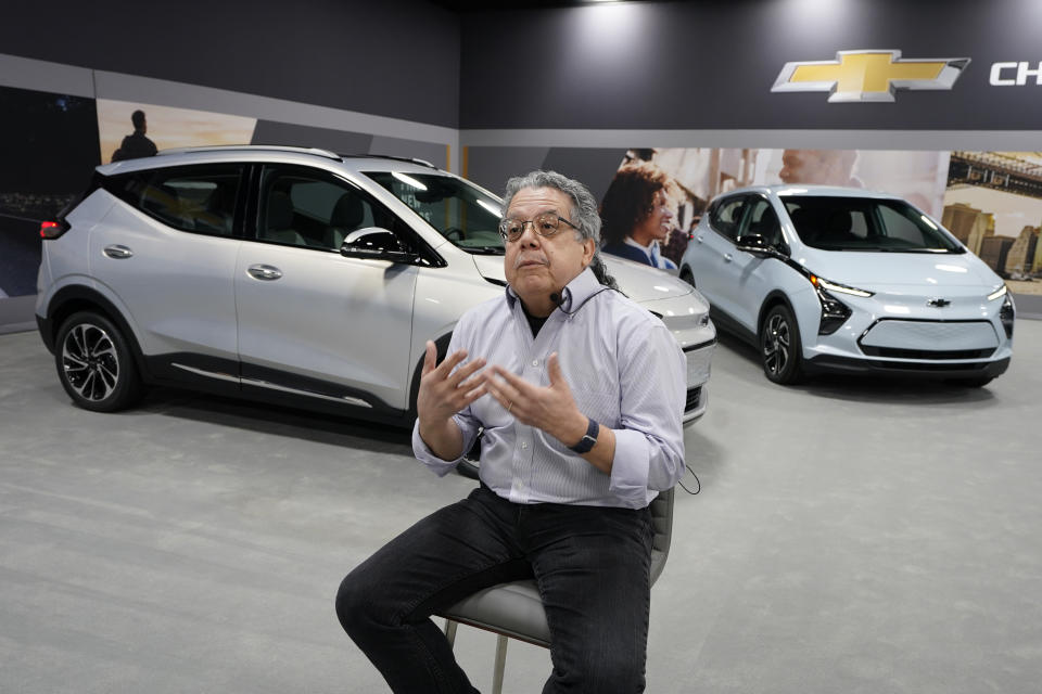 Jesse Ortega, Chevrolet Bolt EUV Executive Chief Engineer is interviewed, Thursday, Feb. 11, 2021, next to a 2022 Bolt EUV, left, in Milford, Mich. Whether people want them or not, automakers are rolling out multiple new electric vehicle models as the auto industry responds to stricter pollution regulations worldwide and calls to reduce emissions to fight climate change. The latest offering comes from General Motors, which unveiled a Chevrolet Bolt compact SUV with a range per charge of 250 miles and a $33,995 starting price tag. It will go on sale in the summer as a 2022 model. (AP Photo/Carlos Osorio)