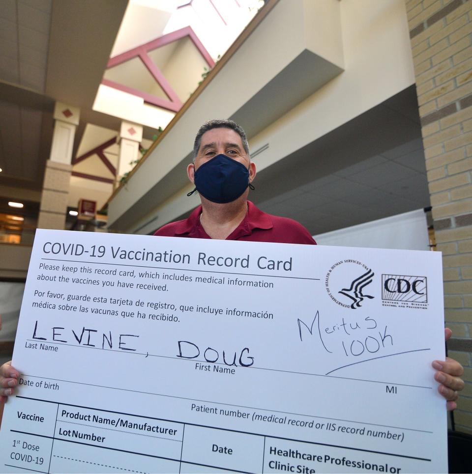 Doug Levine, of Williamsport, receives his second booster shot, which is also the 100,000th vaccine administered at the Meritus COVID-19 vaccination clinic at the Robinwood Professional Center near Hagerstown.