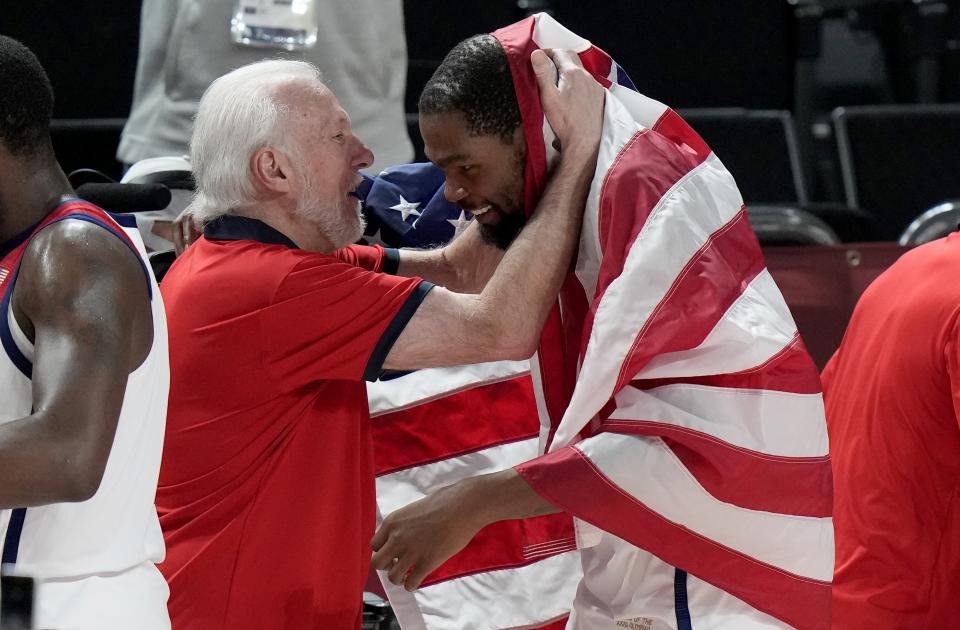 USA's Kevin Durant (right) celebrates with head coach Gregg Popovich after their win in the men's basketball gold medal game against France at the 2020 Summer Olympics on Aug. 7, 2021, in Saitama, Japan.