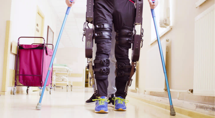 Image of a person using an exoskeleton and crutches to walk.