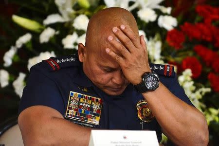 Philippine National Police chief General Ronald Dela Rosa listens as President Rodrigo Duterte announces the disbandment of police operations against illegal drugs at the Malacanang palace in Manila, Philippines January 29, 2017. Picture taken January 29, 2017. REUTERS/Ezra Acayan